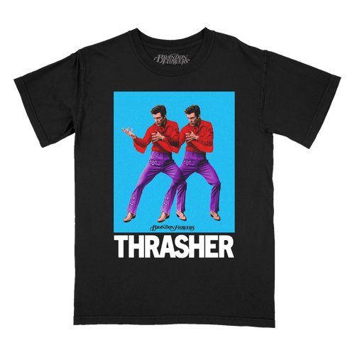 A black short-sleeve graphic t-shirt featuring a large front print of Brandon Flowersn in red shirts and purple pants against a bright blue background, with the word 'THRASHER' in bold white letters below.